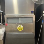 Technician repairing a commercial ice machine at a hospitality venue