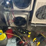 Technician performing a refrigeration breakdown diagnosis by testing electrical components after replacing a PC board.